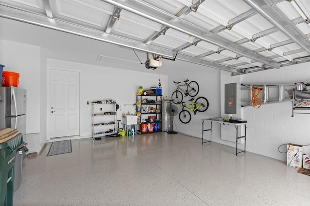 garage featuring electric panel, a garage door opener, stainless steel refrigerator, and water heater