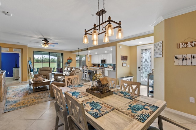 tiled dining space featuring ceiling fan and crown molding