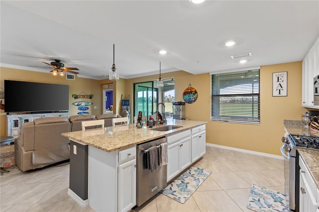 kitchen with pendant lighting, white cabinets, appliances with stainless steel finishes, an island with sink, and sink