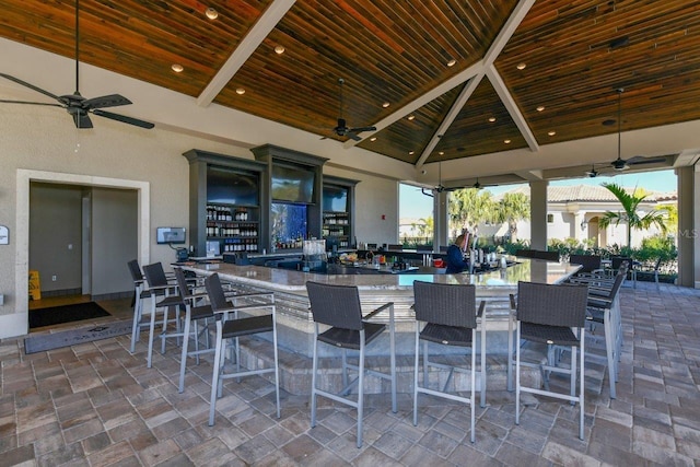 view of patio with ceiling fan, a gazebo, and exterior bar