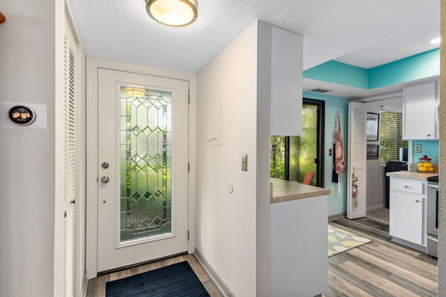 entrance foyer featuring a textured ceiling and light hardwood / wood-style floors