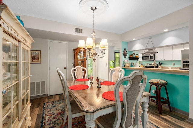 dining area featuring dark wood-type flooring and a chandelier