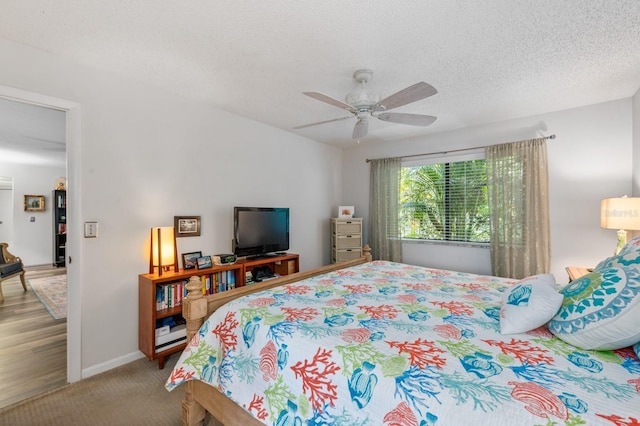 bedroom with a textured ceiling, ceiling fan, and carpet flooring