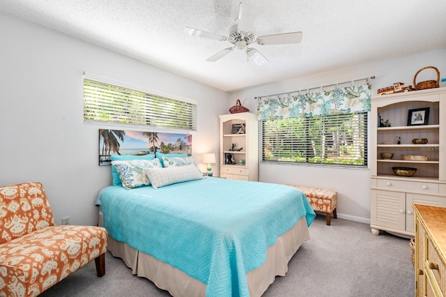 bedroom with ceiling fan, light carpet, and a textured ceiling