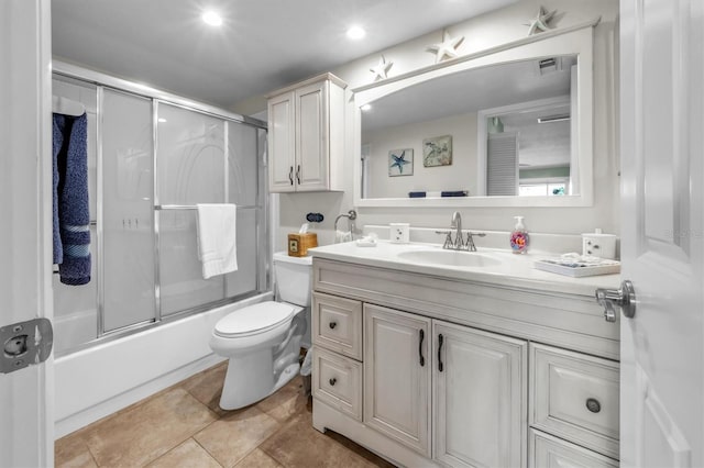 full bathroom featuring toilet, enclosed tub / shower combo, tile patterned floors, and vanity