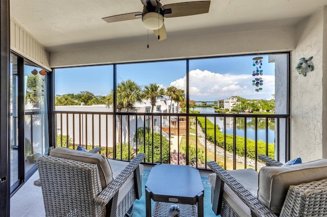 sunroom with a water view, ceiling fan, and plenty of natural light