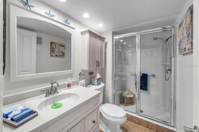 bathroom featuring toilet, tile patterned floors, walk in shower, and vanity