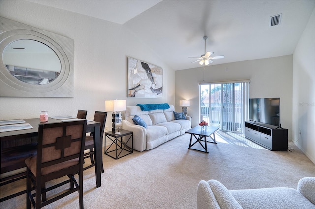 carpeted living room with ceiling fan and lofted ceiling