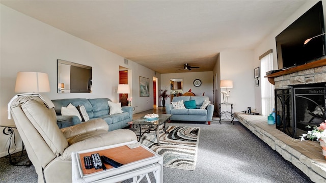 living room with ceiling fan, carpet floors, and a fireplace