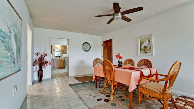 dining area with a textured ceiling, ceiling fan, and light tile patterned floors