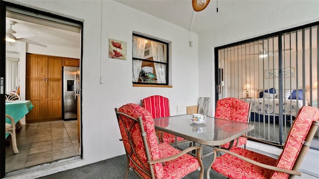 tiled dining space with ceiling fan