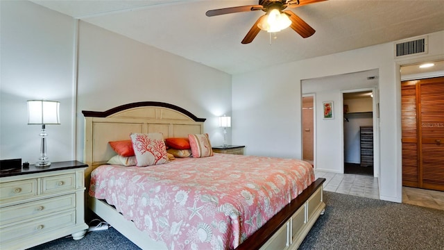 carpeted bedroom with a closet, ceiling fan, and a spacious closet