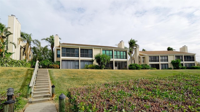 rear view of house featuring a yard