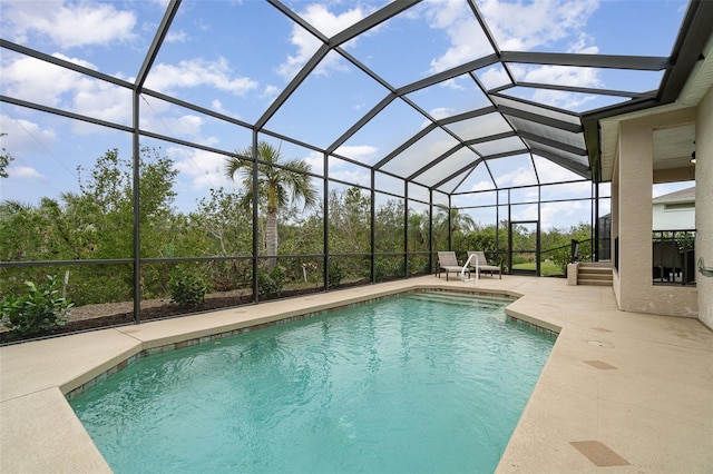 view of swimming pool featuring a patio area and glass enclosure