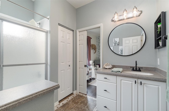 bathroom featuring vanity, tile patterned floors, and a shower with shower door