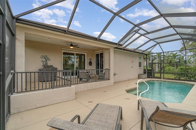 view of swimming pool with a patio area, ceiling fan, and a lanai