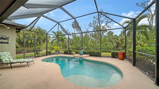 view of pool with glass enclosure and a patio