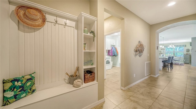 mudroom with tile patterned floors and washer / dryer