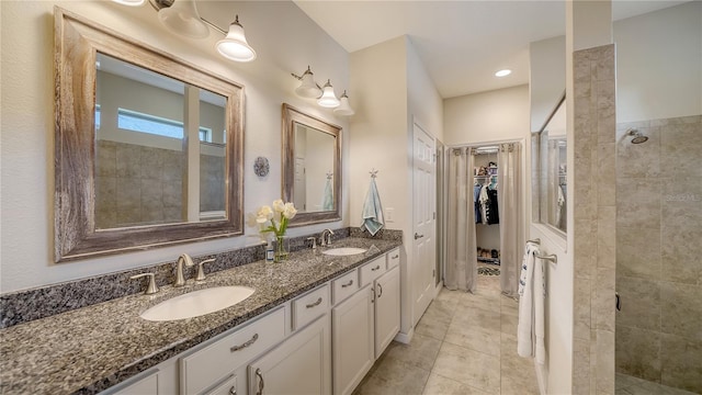 bathroom featuring walk in shower, vanity, and tile patterned flooring