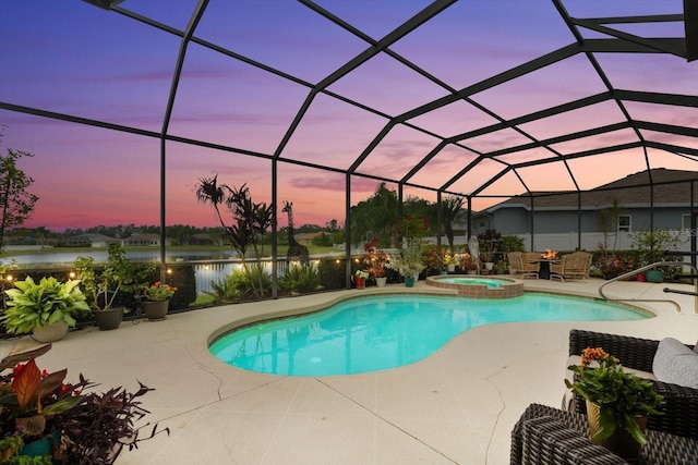 pool at dusk with a lanai, a water view, a patio area, and an in ground hot tub