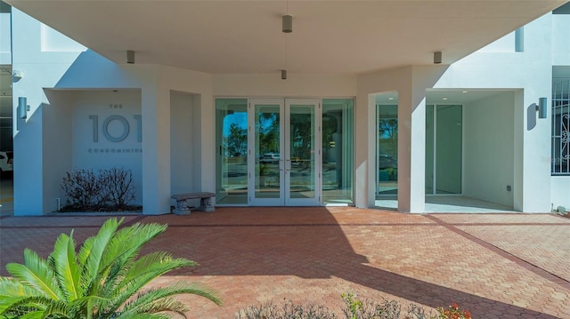 view of exterior entry with french doors and a patio area