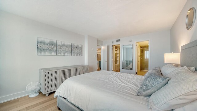 bedroom featuring light hardwood / wood-style flooring and ensuite bathroom