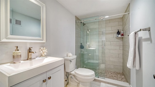 bathroom with toilet, tile patterned flooring, a shower with shower door, and vanity