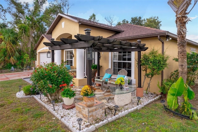 view of front of property featuring a front yard, a pergola, and a garage