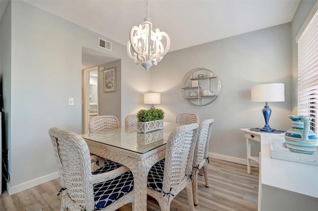 dining area with a chandelier and light hardwood / wood-style floors