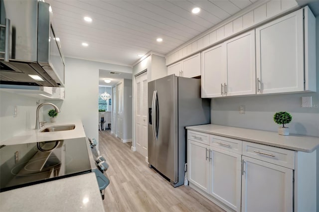 kitchen featuring sink, stainless steel appliances, ornamental molding, light hardwood / wood-style floors, and white cabinets