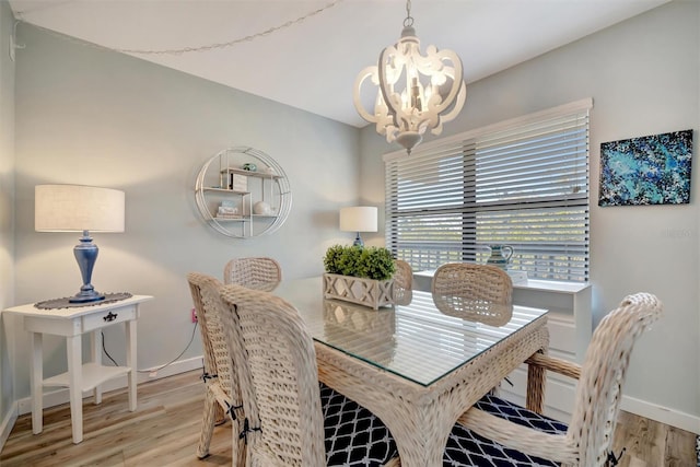 dining space featuring an inviting chandelier and light hardwood / wood-style floors