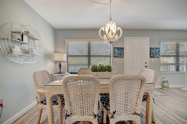 dining area with an inviting chandelier, a healthy amount of sunlight, and light hardwood / wood-style floors