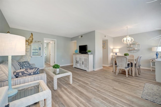 living room featuring a notable chandelier and light hardwood / wood-style flooring