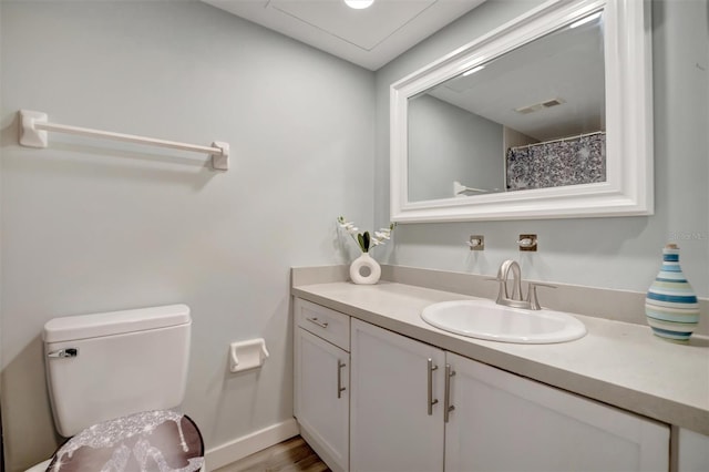 bathroom with hardwood / wood-style flooring, vanity, and toilet