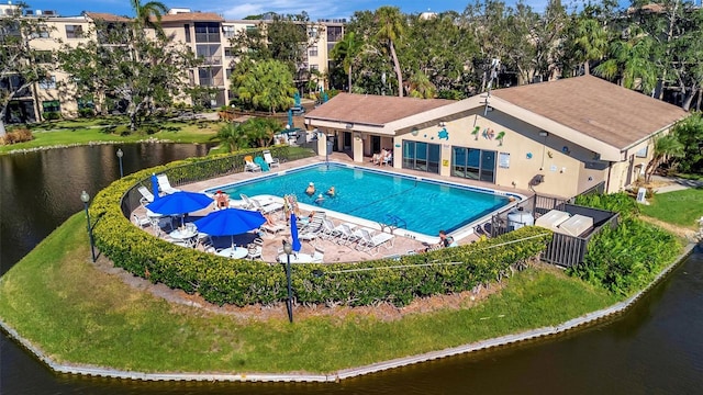 view of pool with a water view, a yard, and a patio area