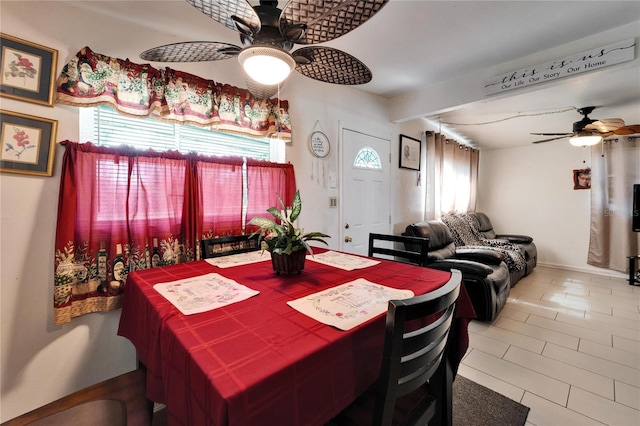 dining room featuring plenty of natural light, beamed ceiling, and ceiling fan