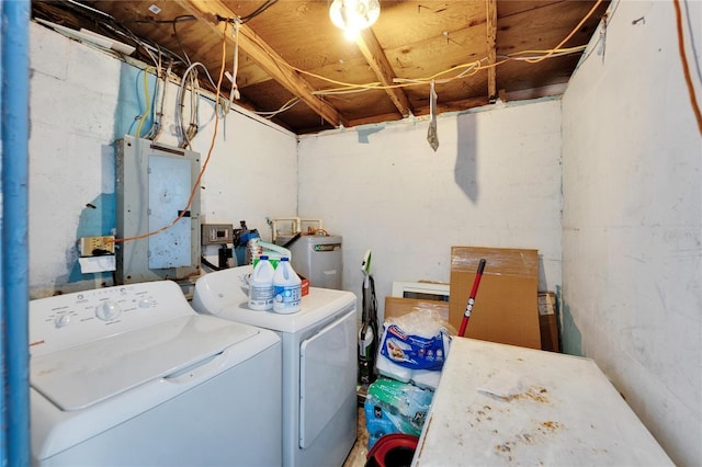 clothes washing area featuring water heater and independent washer and dryer