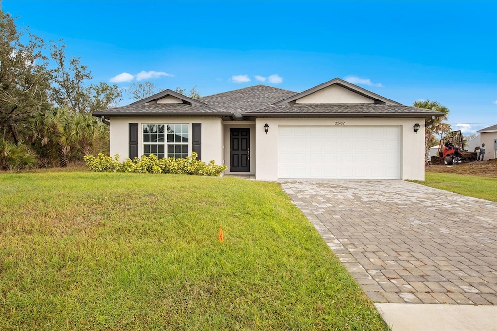 single story home featuring a garage and a front lawn