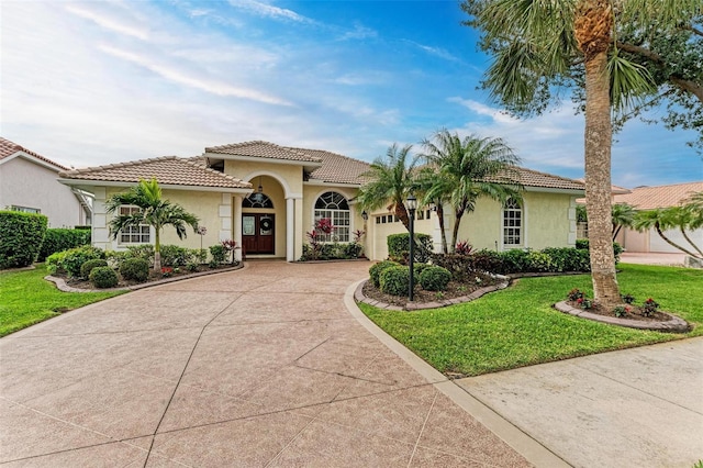 mediterranean / spanish home with a garage and a front yard