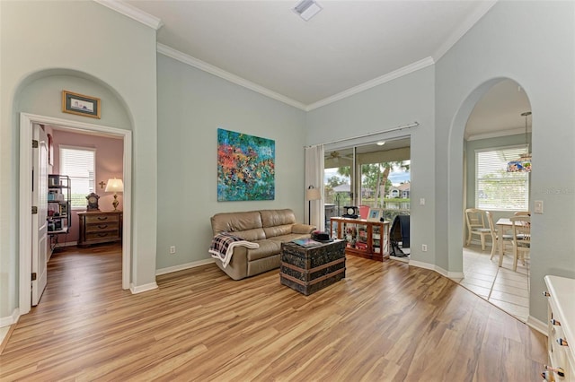 living room with light wood-type flooring, crown molding, and plenty of natural light