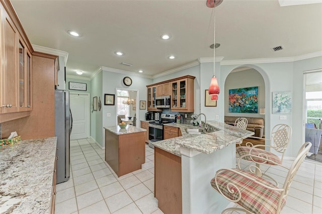 kitchen with stainless steel appliances, hanging light fixtures, light stone countertops, kitchen peninsula, and a kitchen bar