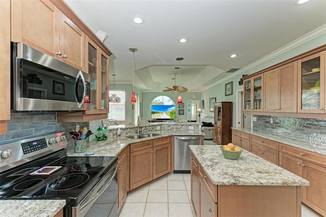 kitchen featuring kitchen peninsula, pendant lighting, a center island, appliances with stainless steel finishes, and sink