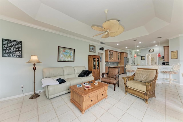 living room with ceiling fan, crown molding, light tile patterned flooring, and a raised ceiling