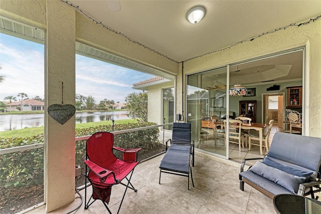 sunroom featuring a water view