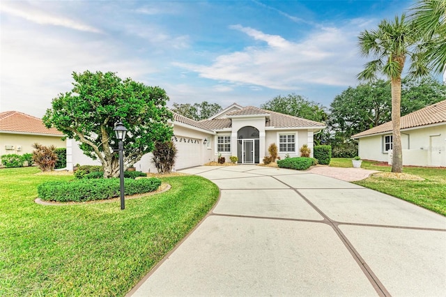 mediterranean / spanish-style home featuring a front lawn and a garage