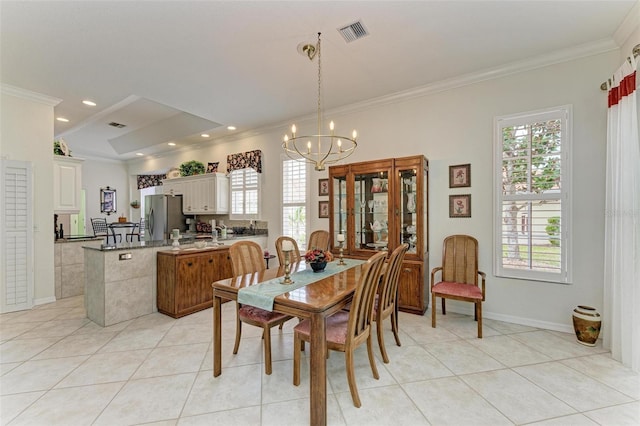 dining area with a notable chandelier, ornamental molding, and light tile patterned floors