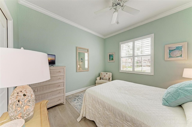 bedroom featuring ornamental molding, ceiling fan, and light wood-type flooring