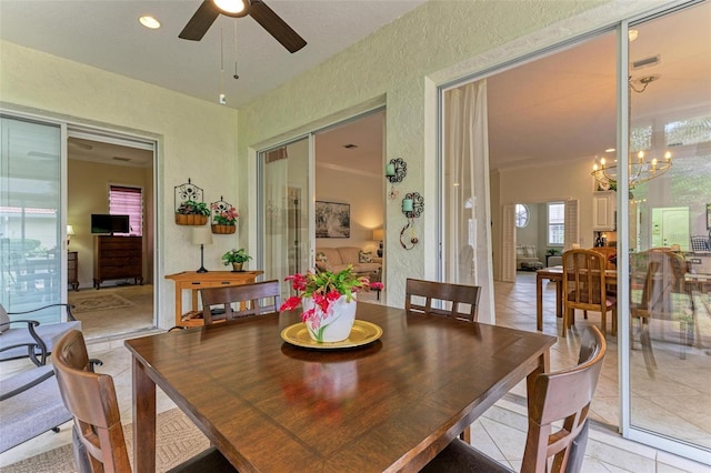 dining room featuring ceiling fan with notable chandelier and light tile patterned flooring