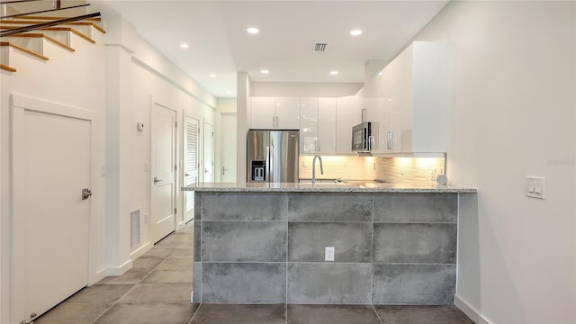 bathroom featuring tasteful backsplash, recessed lighting, visible vents, and a sink