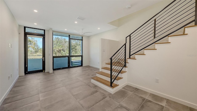 entryway featuring recessed lighting, visible vents, baseboards, stairs, and floor to ceiling windows